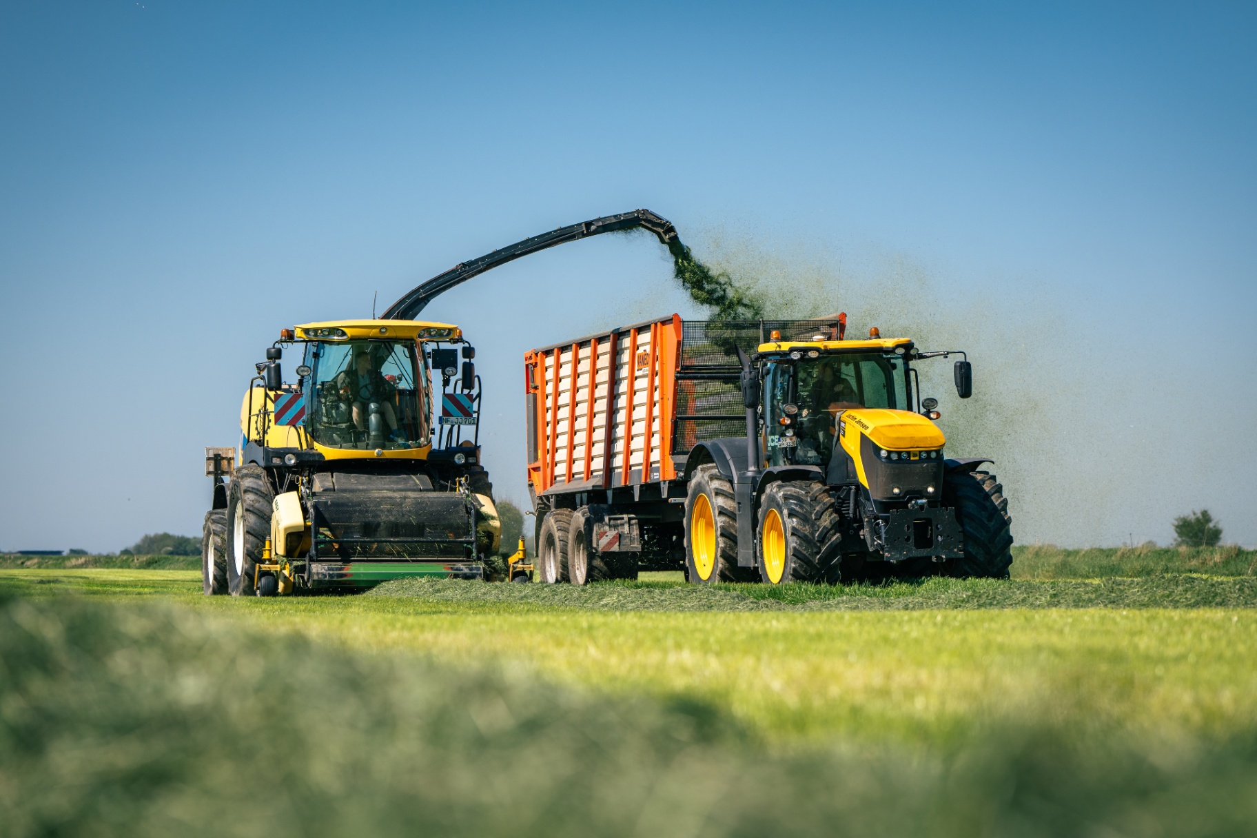 Häcksler und Abfuhrgespann bei der Grasernte
